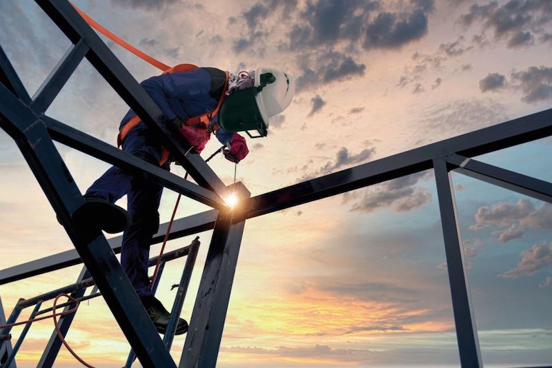 soldador trabajando en altura con protección anticaídas